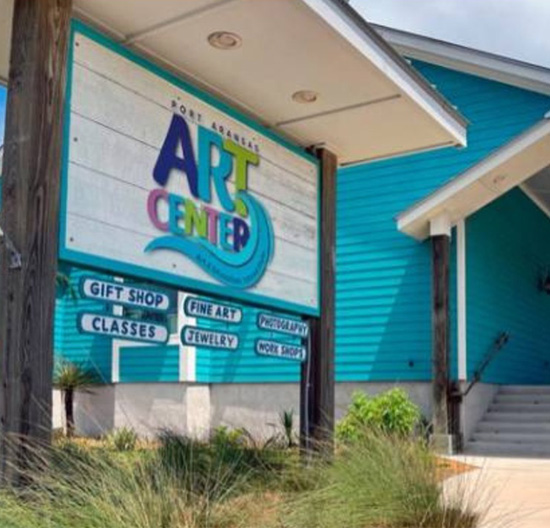 Port Aransas Art Center with blue exterior and signage for art, jewelry, and workshops