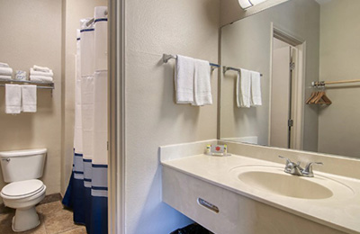 Bathroom of 2 Full Bed Kitchen Room at Alister Square Inn with sink, towels, and shower area