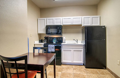 Kitchen area of 2 Full Bed Kitchen Room at Alister Square Inn with fridge, microwave, and table