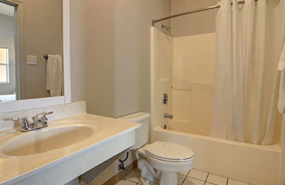 Bathroom of Deluxe Suite at Alister Square Inn with sink, toilet, and shower area
