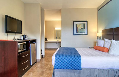Accessible 1 Queen Room at Alister Square Inn with cozy bed, desk, and bright lighting