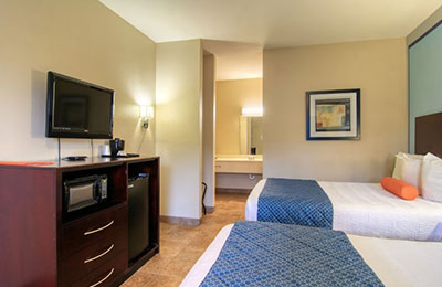 Comfortable 2 Queen Bed Room at Alister Square Inn with blue accents and a flat-screen TV