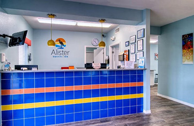 Reception area of Alister Square Inn with blue tiled desk and welcoming decor in Port Aransas