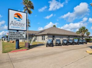 Exterior view of Alister Square Inn with golf carts – book your stay and enjoy current Port Aransas hotel deals